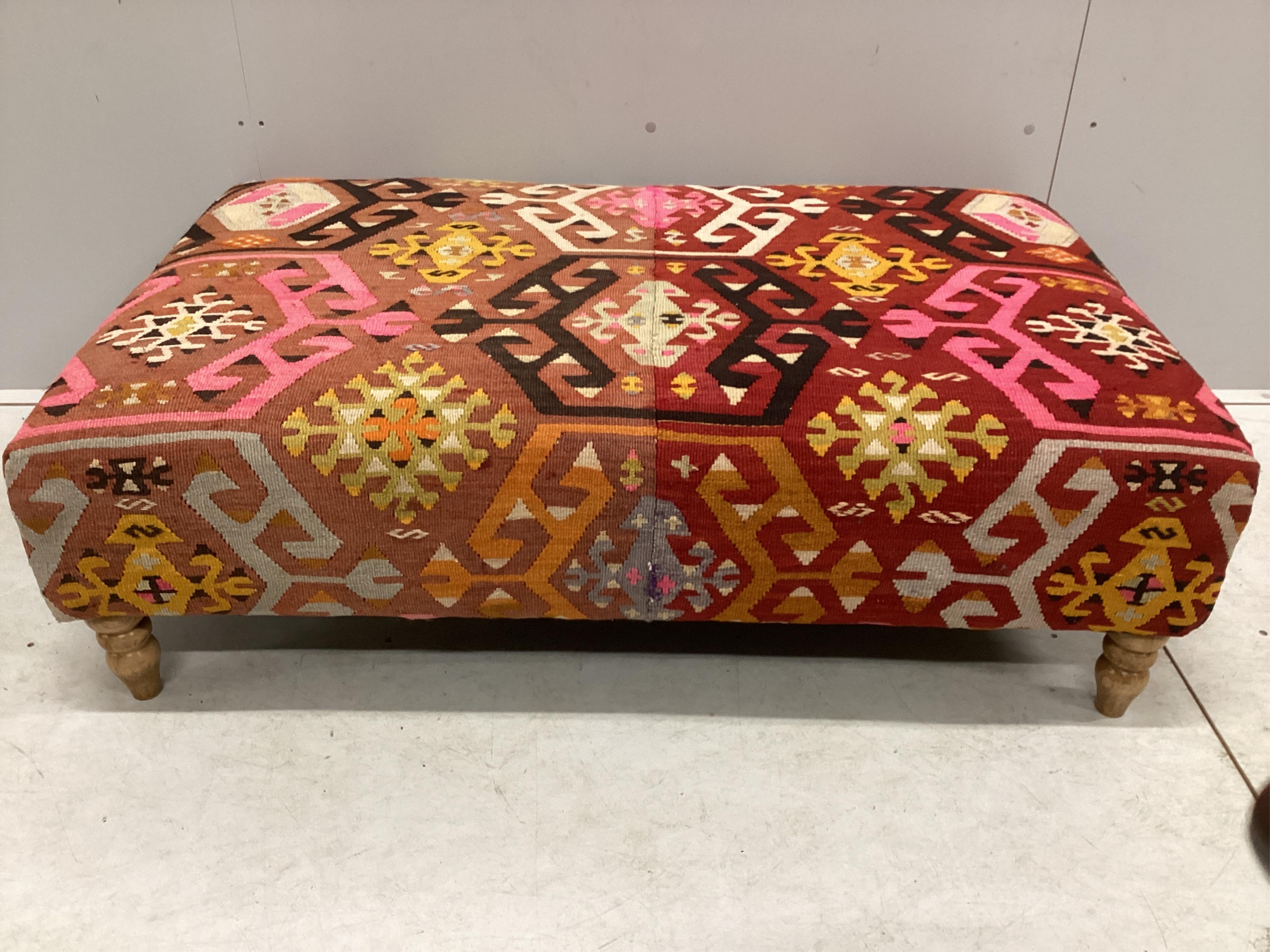 A large contemporary rectangular footstool with antique polychrome Kilim upholstery on turned beech feet, width 124cm, depth 78cm, height 40cm. Condition - good